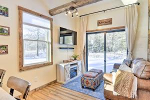 a living room with a couch and a tv and a window at Cozy Home with Yard about 6 Mi to Stowe Mountain! in Stowe