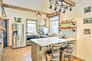 a kitchen with a large island with bar stools at Cozy Home with Yard about 6 Mi to Stowe Mountain! in Stowe