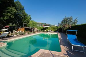 a large swimming pool with two chairs around it at Casa Biagiotti in Cortona