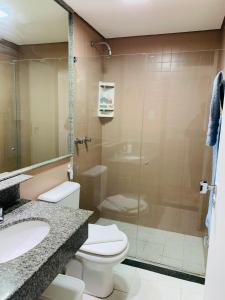 La salle de bains est pourvue de toilettes et d'une douche en verre. dans l'établissement Studio perto do Cristo carnaval circuito ondina, à Salvador