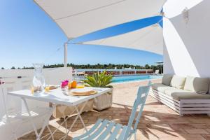 un patio con tavolo e sedie e una piscina di Ocean view beach villa a Budens