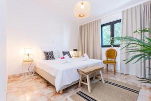 una camera da letto bianca con un letto e una sedia di Ocean view beach villa a Budens