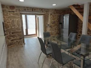 a dining room with a glass table and chairs at Casa Alberto in A Guarda
