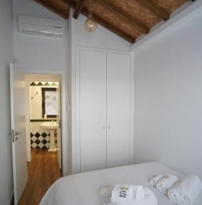 1 dormitorio con 1 cama con sábanas blancas y toallas en Modern house - air cond, free parking, breakfast, en Vila Nova de Gaia