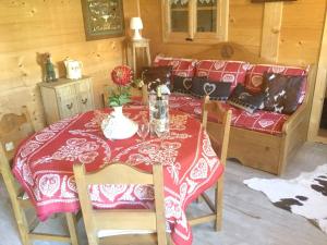 uma mesa de jantar com uma toalha de mesa vermelha e branca em Villa d'une chambre avec piscine privee sauna et jardin clos a Allinges em Allinges