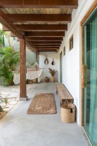 een veranda met een bank en een hangmat bij Tropical Beach in Porto Seguro