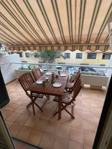 Una mesa y sillas de madera en un patio. en Balancon Medano, en El Médano
