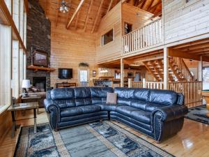 a leather couch in a living room with a wooden ceiling at Copper Top - Stunning Views, and Hot Tub in Sevierville