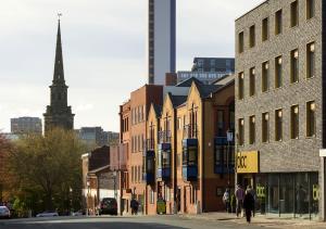 a group of buildings on a city street with a church at Bloc Hotel Birmingham in Birmingham