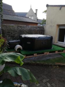 a large tub sitting on a table in a yard at LE COCON de MATIGNON Gîte 4 étoiles 5 kms mer in Matignon