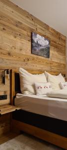 una camera da letto con una parete in legno e 2 letti di Frühstückspension Bachseitenhof a Radstadt