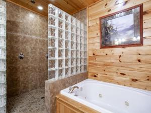a bathroom with a tub and a shower with wooden walls at Million Dollar View - Hot Tub, and Sauna! in Sevierville +71 photos