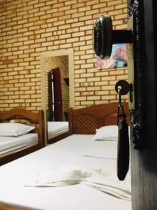 a bedroom with two beds and a phone on the door at Hotel Olho D'água - Baturité in Baturité