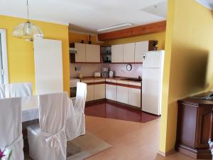 a kitchen with white cabinets and a table with chairs at Ferienwohnung Fam. Schade in Beilrode