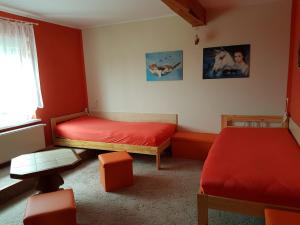 a bedroom with two beds with red sheets and a window at Ferienwohnung Fam. Schade in Beilrode