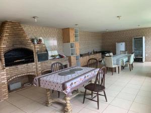 a kitchen with a table and a brick oven at Sitio Bom Retiro in São Pedro da Aldeia