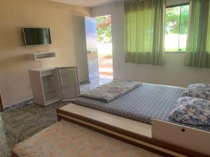 a bedroom with a bed and a television in it at Sitio Bom Retiro in São Pedro da Aldeia