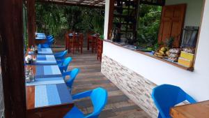 
a row of tables with chairs and a blue tablecloth at Aracari Garden Hostel in Tortuguero
