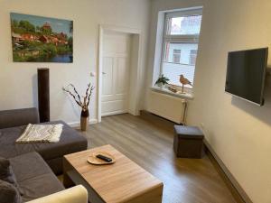 a living room with a couch and a table at Das BilderbuchCafe - Ferien - Apartment NO 3 - Markt 7 in Havelberg