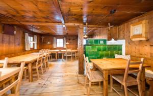 a dining room with wooden tables and chairs at Stern LODGE im Bergparadies Lechtal in Boden