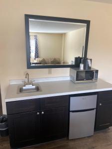 a kitchen counter with a sink and a mirror at University Inn Duke in Durham
