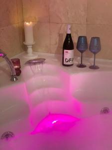 a bottle of wine and wine glasses in a bathroom sink at Casa din Deal in Sibiu