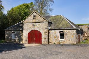 uma velha igreja de pedra com uma porta vermelha em Balmule House em Dunfermline