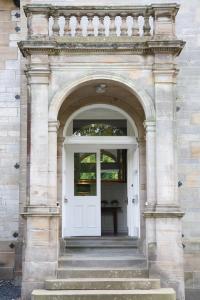 uma entrada para um edifício com uma porta branca em Balmule House em Dunfermline