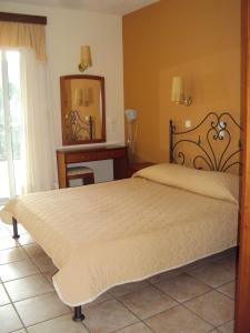 a bedroom with a large bed and a mirror at Amalia in Paleo Tsifliki