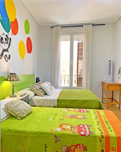 Un dormitorio con dos camas con sábanas verdes. en Sweet Home Salamanca, en Salamanca