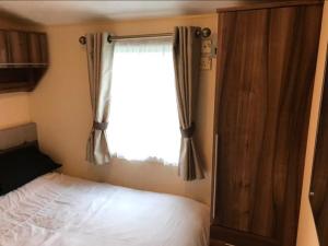 En eller flere senge i et værelse på The Winchester luxury pet friendly caravan on Broadland Sands holiday park between Lowestoft and Great Yarmouth