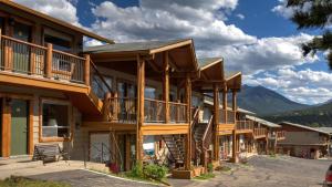 a row of wooden buildings with mountains in the background at Hotel Estes in Estes Park
