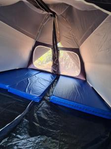 een tent met twee stoelen en twee ramen in het water bij Camping Valle das Aguas in Socorro