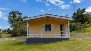 a small yellow house with a porch at Pousada Vale do Ouro Verde in Serra Negra