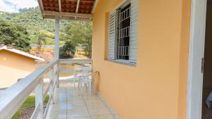 a balcony of a house with a table and chairs at Pousada Vale do Ouro Verde in Serra Negra