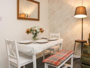 a white table with chairs and a vase of flowers at Pippin's Place in Shrewsbury