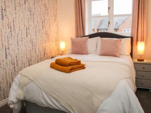 a bedroom with a bed with a blanket and two lamps at Pippin's Place in Shrewsbury