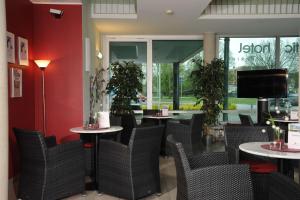 a restaurant with tables and chairs and a large window at Atlantic Hotel am Floetenkiel in Bremerhaven