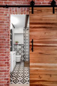 een badkamer met een bakstenen muur en een houten deur bij Apartment Ami in Split +45 foto's