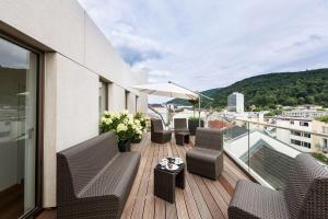 einen Balkon mit Stühlen und einem Tisch auf einem Gebäude in der Unterkunft Bergheim 41 Hotel im Alten Hallenbad in Heidelberg