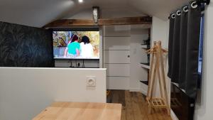 a living room with a flat screen tv on the wall at Studio chaleureux en hyper centre in Charleville-Mézières