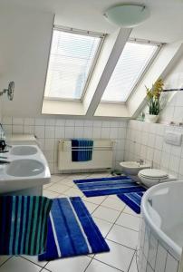 a bathroom with two sinks and blue rugs at luxury 4 bedroom roof apt with 3 balconies & view in Vienna