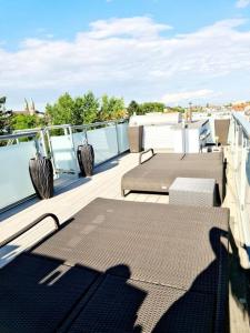 a deck with two tables and chairs on a balcony at luxury 4 bedroom roof apt with 3 balconies & view in Vienna