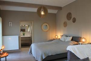 a bedroom with a bed and two lamps and a mirror at La Veraison in Malmedy