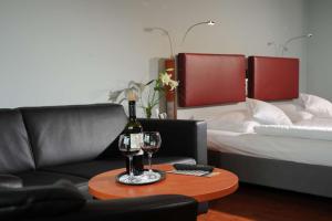 a living room with a couch and a table with a wine glass at Nordsee Hotel Fischereihafen in Bremerhaven