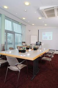 une salle de conférence avec une grande table et des chaises dans l'établissement Nordsee Hotel Fischereihafen, à Bremerhaven