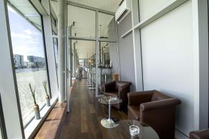 a room with chairs and tables and large windows at Nordsee Hotel Fischereihafen in Bremerhaven