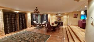 a dining room and living room with a table and chairs at Nasr City Royal in Cairo