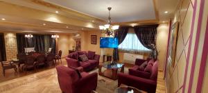 a living room with purple chairs and a dining room at Nasr City Royal in Cairo