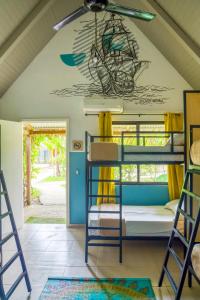 a room with bunk beds and a ceiling with a mural at Selina Playa Venao in Playa Venao